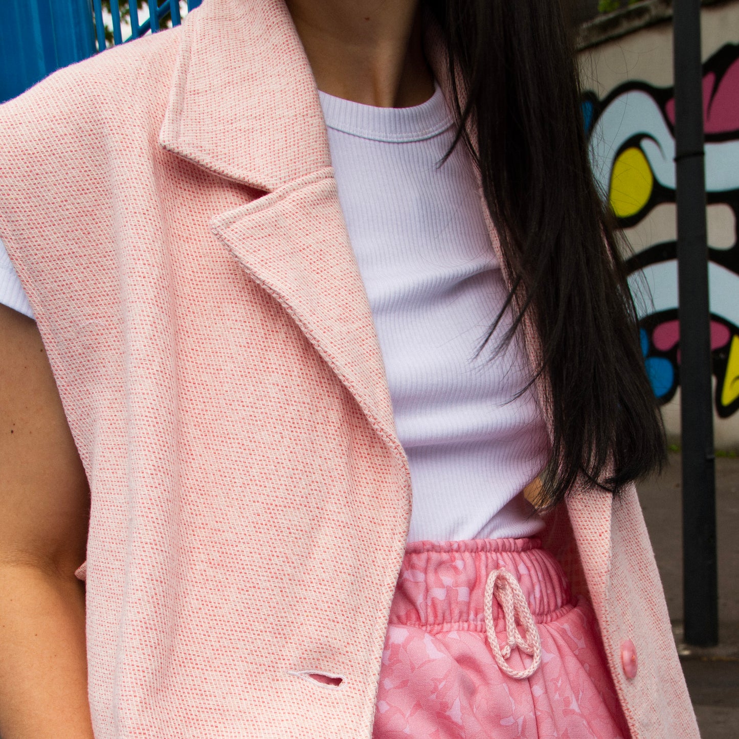 Lucewear: femme portant une veste sans manche en tweed rose